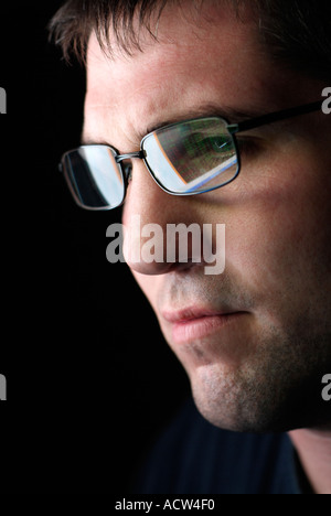 Mans Face with Spectacles Reflecting the Display of a Computer Monitor Stock Photo