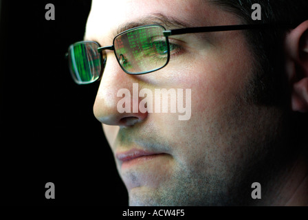 Face of a Stockbroker with Spectacles Reflecting the Display of a Computer Monitor Full of Share Prices Stock Photo