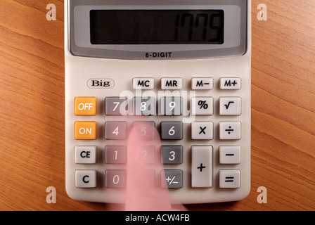 Blurred Motion of a Finger Pressing Buttons on a Calculator Stock Photo