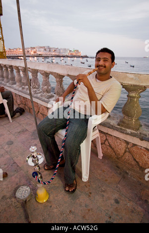 Yemeni man smoking the waterpipe on Al Mukhalla Corniche Yemen Stock Photo