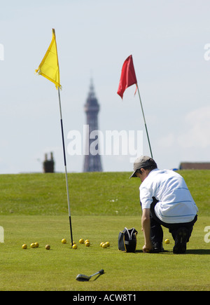 Golf course flags and Blackpool Tower Young boy collecting balls Stock Photo