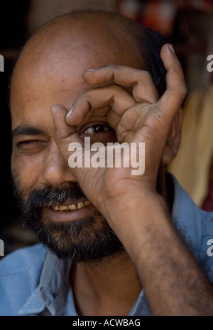 Indian man peeking through a hole Varanasi Benares India Stock Photo