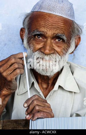 Old handy man repairing a chair Delhi India Stock Photo