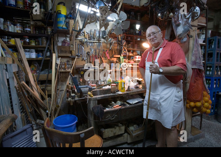 A guy in a workshop toolshed with a billiard cue Buenos Aires Argentina Stock Photo