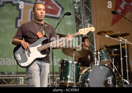 A bass player performing on a stage with a band at World Village Festival at Kaisaniemi, Helsinki, Finland, EU Stock Photo
