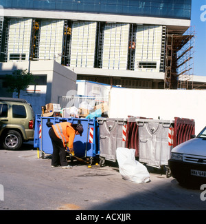 A street cleaner sweeping up the area around rubbish bins in Athens Greece Stock Photo