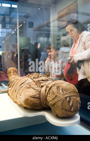 Visitors looking at an ancient Egyptian mummy in the British Museum, London, England, UK Stock Photo