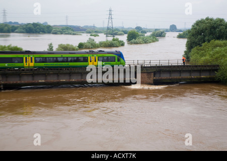train going over bridge on the flooded river severn in gloucester uk Stock Photo