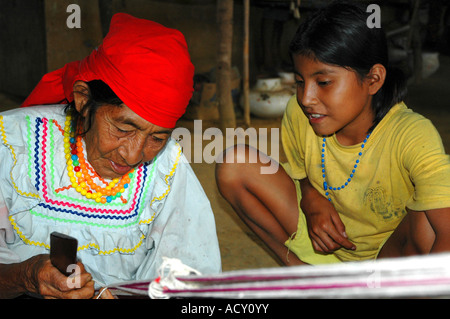 Old woman teaching her granddaughter how to weave Yurimahuas Peru Stock Photo