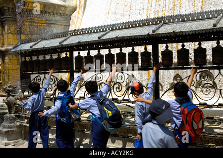 Schoolboys spinning prayer wheels. Swayambhunath Stupa. Kathmandu. Nepal Stock Photo