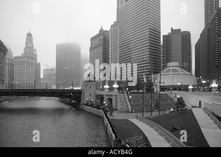 man sleeping on the lawn in downtown chicago on a foggy summer morning Stock Photo