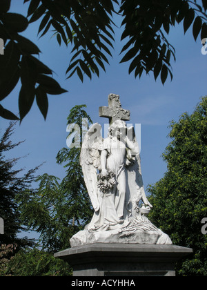 statue of Angel Gabriel among trees in cemetery Roermond Limburg Holland Netherlands Stock Photo