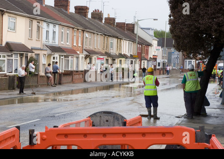 Residents help clean up after a burst water main floods their homes during a hosepipe ban in Swindon Wiltshire Stock Photo