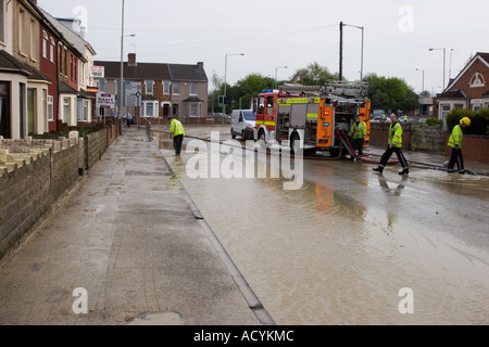 Residents help clean up after a burst water main floods their homes during a hosepipe ban in Swindon Wiltshire Stock Photo