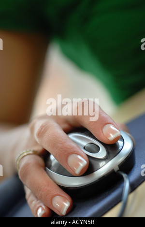 Womans hand using a computer mouse with scroll wheel in an office Stock Photo