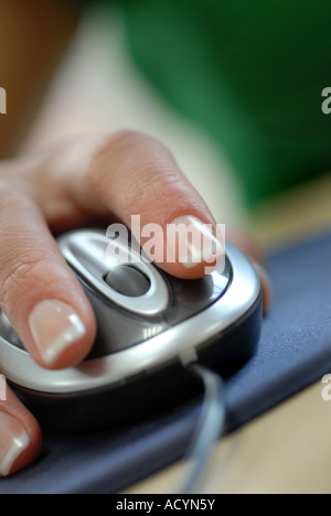 Womans hand using a computer mouse with scroll wheel in an office Stock Photo