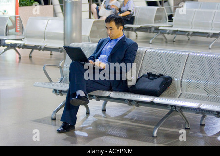 Chinese Businessman Typing on Laptop PVG Pudong International Airport Shanghai China Stock Photo