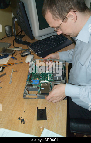 Engineer repairing a laptop computer changing motherboard Stock Photo
