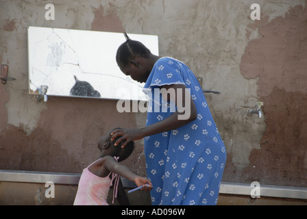A woman washing her daughter at an African asylum seeker compound in southern Israel