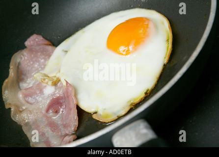 detail close up of egg and tomatoes cooking in a frying pan for breakfast Stock Photo