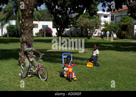 Local African children playing outside their homes on housing development with parents in background Accra Ghana Stock Photo