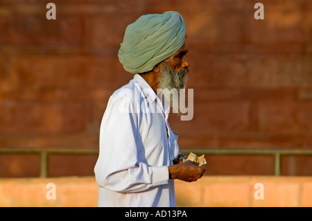 Horizontal portrait of an elderly Indian man counting his rupees at the entrance of the Red Fort Stock Photo