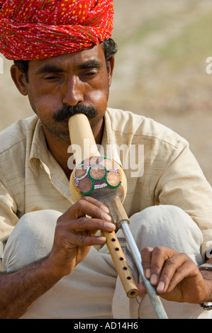 Vertical close up portrait of a snake charmer playing the traditional Indian wind instrument the punji. Stock Photo