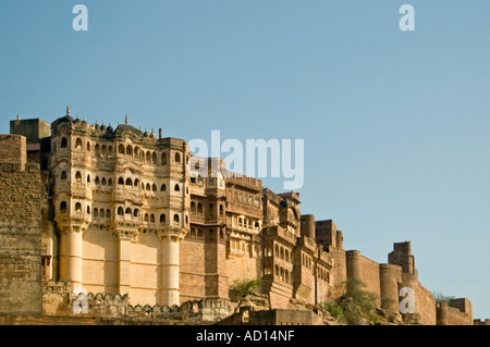 Horizontal wide angle of the imposing exterior of Mehrangarh Fort in Jodhpur against a bright blue sky.