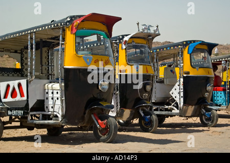 Horizontal close up of a row of sparkling clean yellow and black auto rickshaws parked outisde the 'Mehrangarth Fort' in Jodhpur Stock Photo