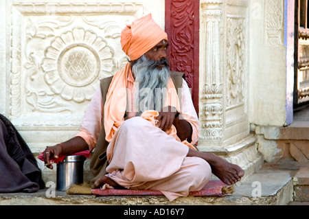 Horizontal portrait of an ascetic Sadhu sitting cross legged outside the Ramavaikunth Temple in Pushkar Stock Photo