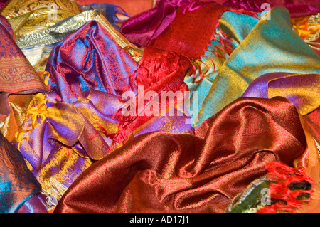 India Uttar Pradesh Varanasi April 2006. Horizontal close up of colourful silk saris strewn all over the floor in a shop Stock Photo