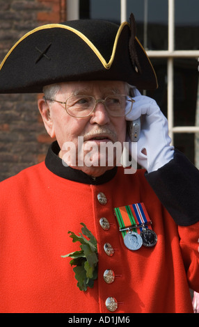 Chelsea Pensioner using mobile phone Wearing uniform and Tricorn hat. Oak Apple leaves and medals. London England  2006 UK 2000s HOMER SYKES Stock Photo