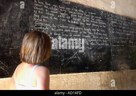 young white south african girl looking at a school blackboard in Malawi Stock Photo