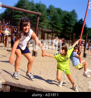 Girls playing in a playground at Pembrey Country Park Lanelli Carmarthenshire Wales UK  KATHY DEWITT Stock Photo