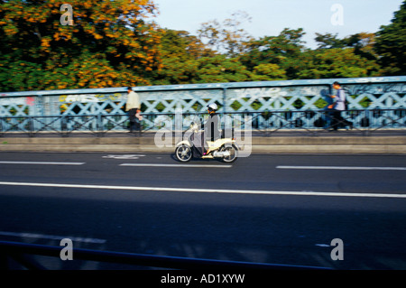 Man on a scooter motorcycle going to work in the road down Rue Caulaincourt Monmartre Paris France Stock Photo