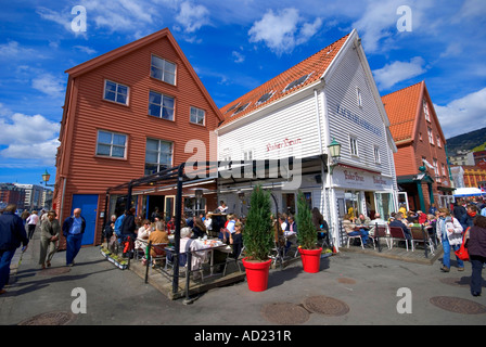 People relax in the sunshine at an outdoor restaurant by Fisketorget square in Bergen Norway Stock Photo