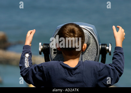 Kid looking through coin operated binoculars Stock Photo