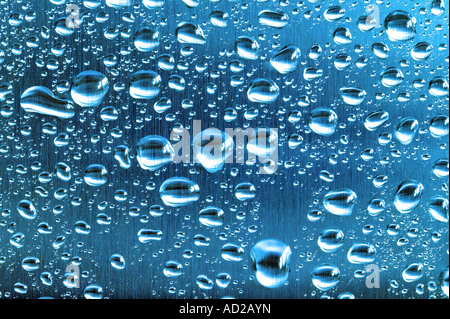 Water droplets on a blue toned brushed steel surface Stock Photo