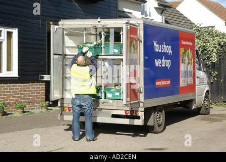 Rear view open Tesco supermarket home delivery van & male driver delivering grocery online internet shopping food direct to house Essex England UK Stock Photo