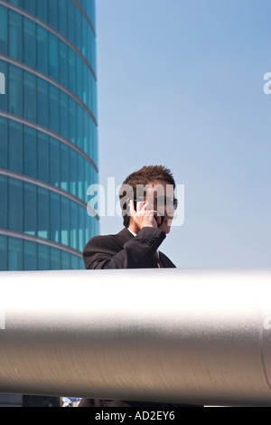 Young businessman talk on mobile phone in More London Place development near City Hall London Stock Photo