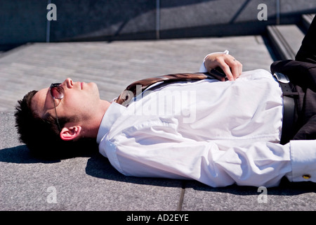 Young businessman relaxes in More London Place development near City Hall London Stock Photo