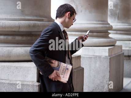Young businessman carries Financial Times newspaper in the City of London Stock Photo