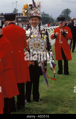 Chelsea Pensioners enjoy a day at Royal Ascot horse races chatting to eccentric British mascot man covered with pin button badges 1990s UK HOMER SYKES Stock Photo