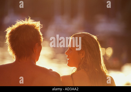 Young couple sitting in warm summer sun Stock Photo