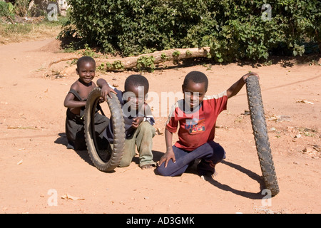 Boys play with old tyres in a street in Monze Zambia Stock Photo