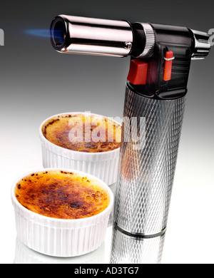COOKS BLOWTORCH WITH CREME BRULLE Stock Photo