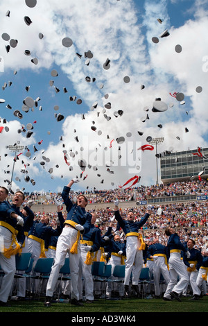 Newly commissioned U.S. Naval Officers celebrate by throwing their hats in the air. Stock Photo