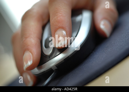 Womans hand using a computer mouse with scroll wheel in an office Stock Photo