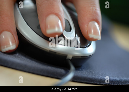 Womans hand using a computer mouse with scroll wheel in an office Stock Photo