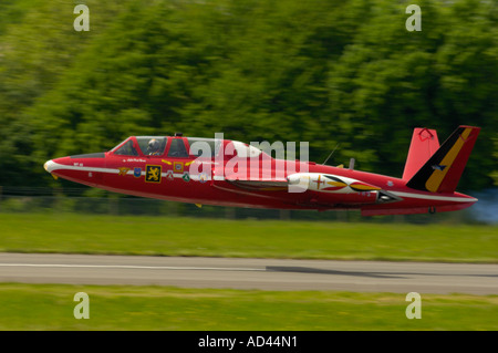 A red Fouga Magister CM-170R taking off from a runway. Stock Photo